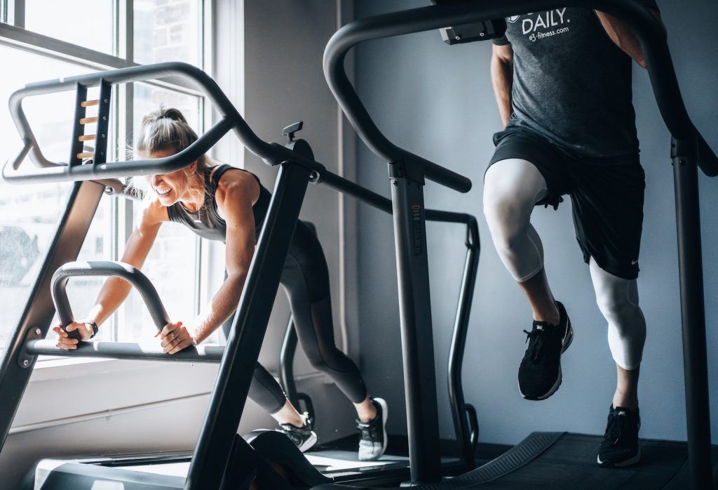 A man and a woman working out on exercise equipment