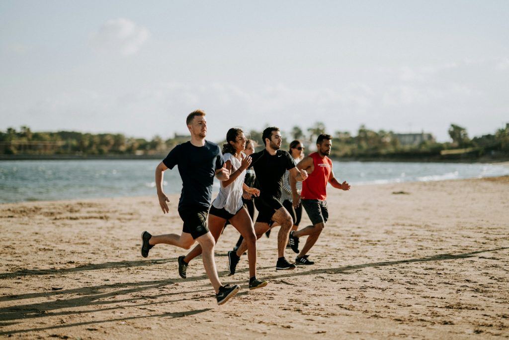 unlock your health potential with men and women running on sea shore