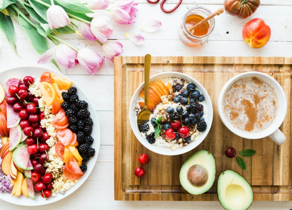 an avocado black and red cherries in a white bowl part of a balanced diet