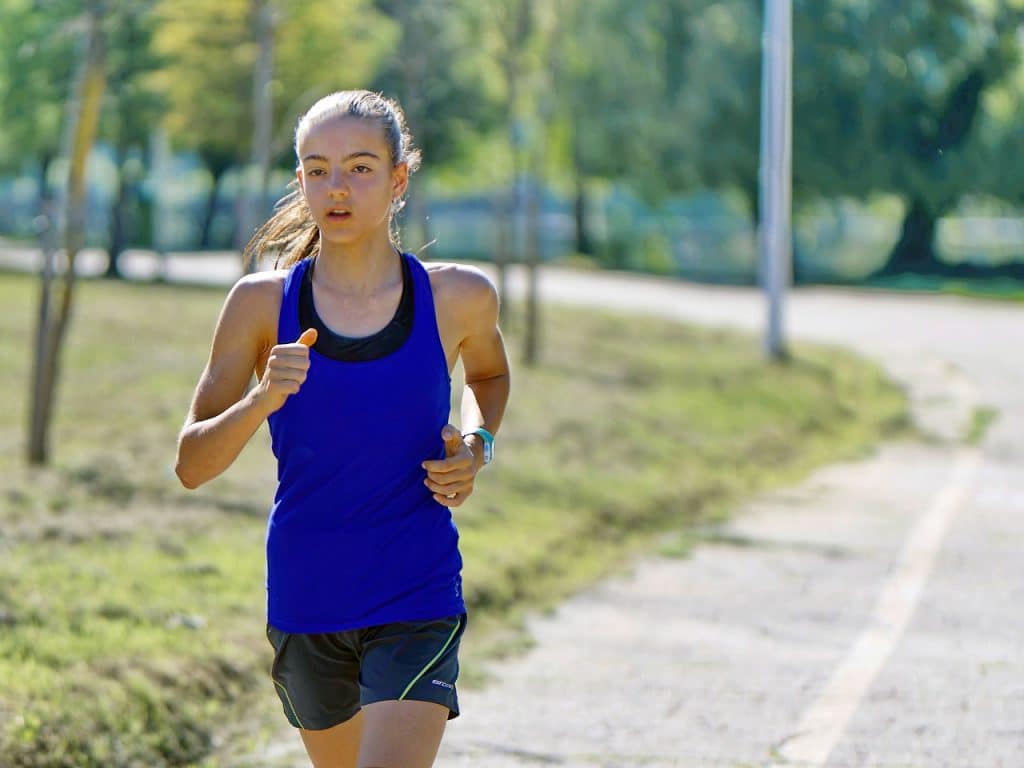 a woman jogging in the park as part of her customized diet and exercise plan