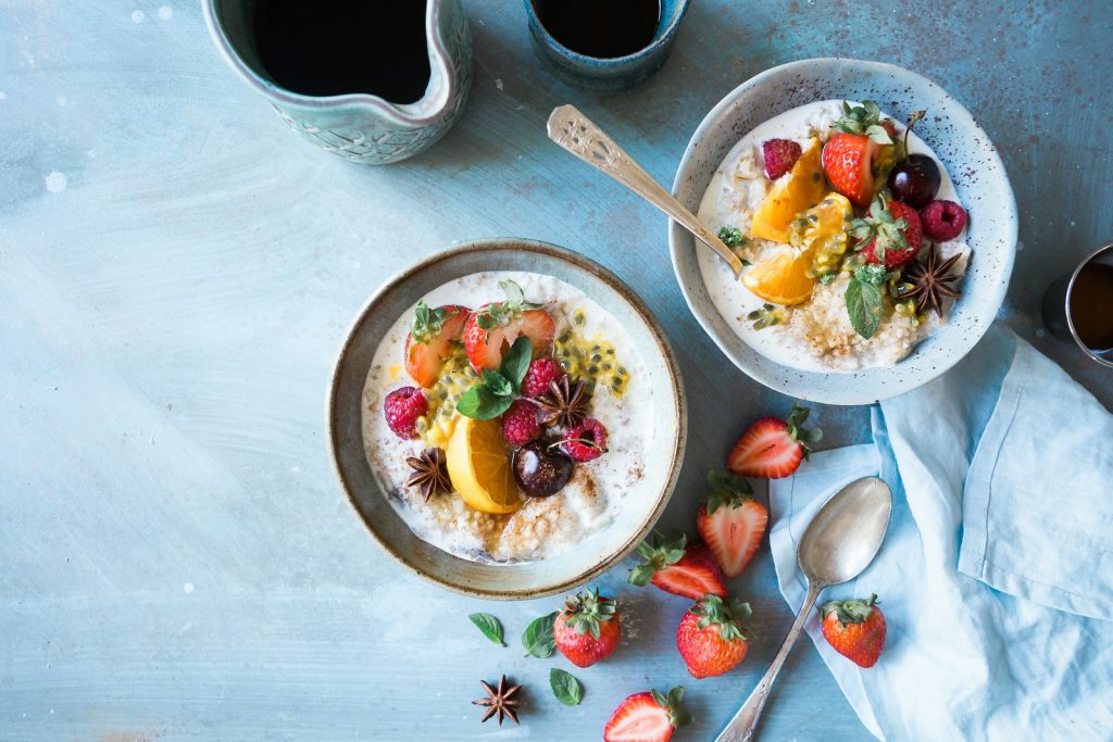 Two bowls of oatmeal with fruits are part of a speedy custom diet and exercise plan